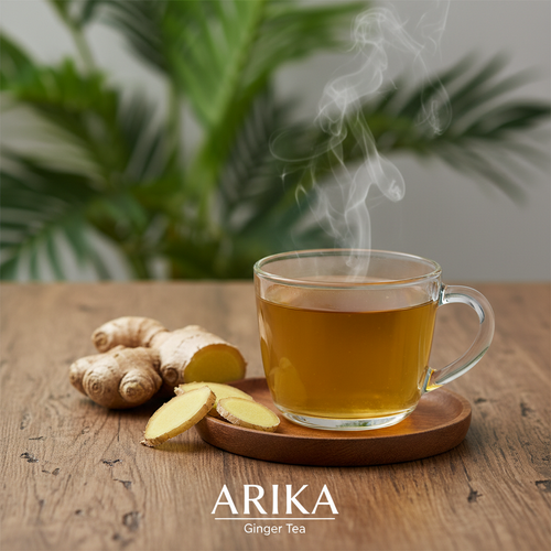 A glass cup of golden ginger tea with fresh ginger root slices on a wooden surface